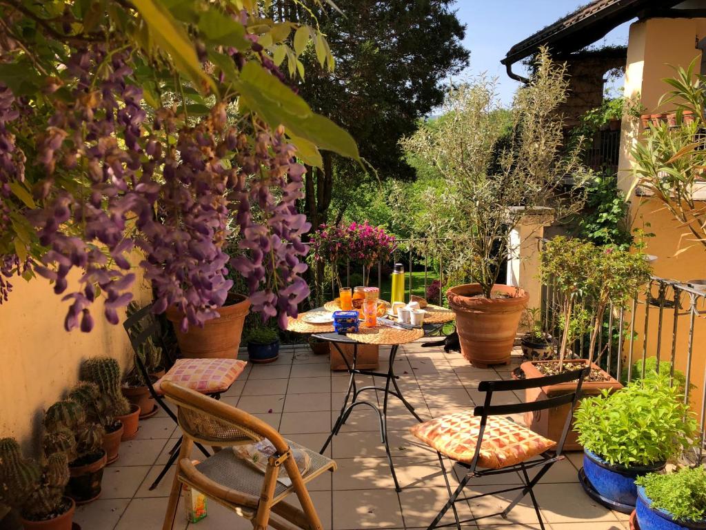 een patio met een tafel, stoelen en planten bij Chez Marianne "chambres d'hôtes" in Astano