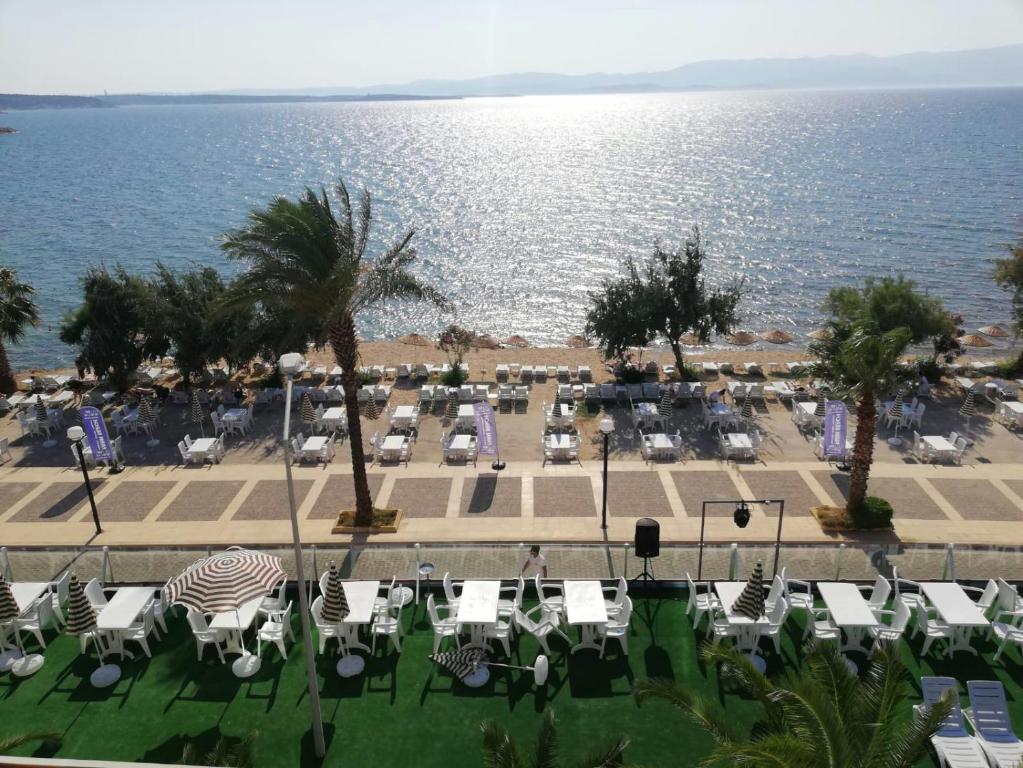 a view of a beach with chairs and the ocean at Çeşme Farm Hotel in Çeşme