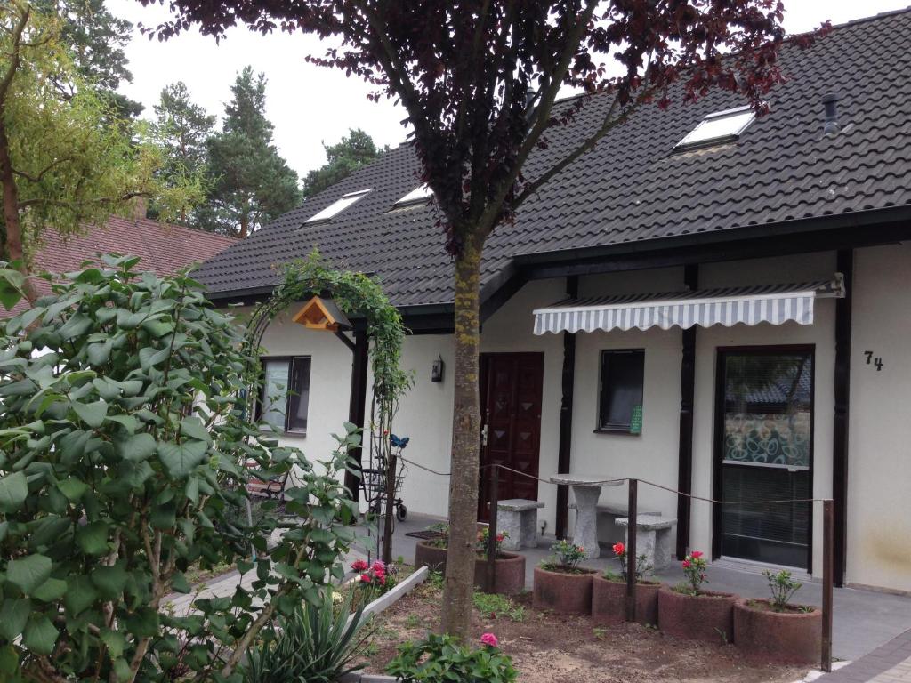 a white house with a tree in the yard at Little paradise in Berlin