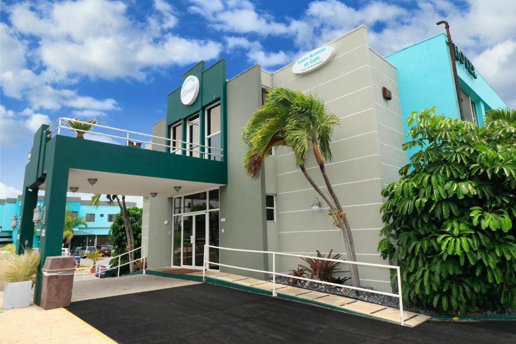 a building with a palm tree in front of it at Parador El Buen Cafe in Hatillo