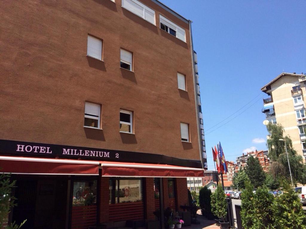 un grand bâtiment en briques avec un hôtel dans l'établissement Hotel Millenium2, à Prizren