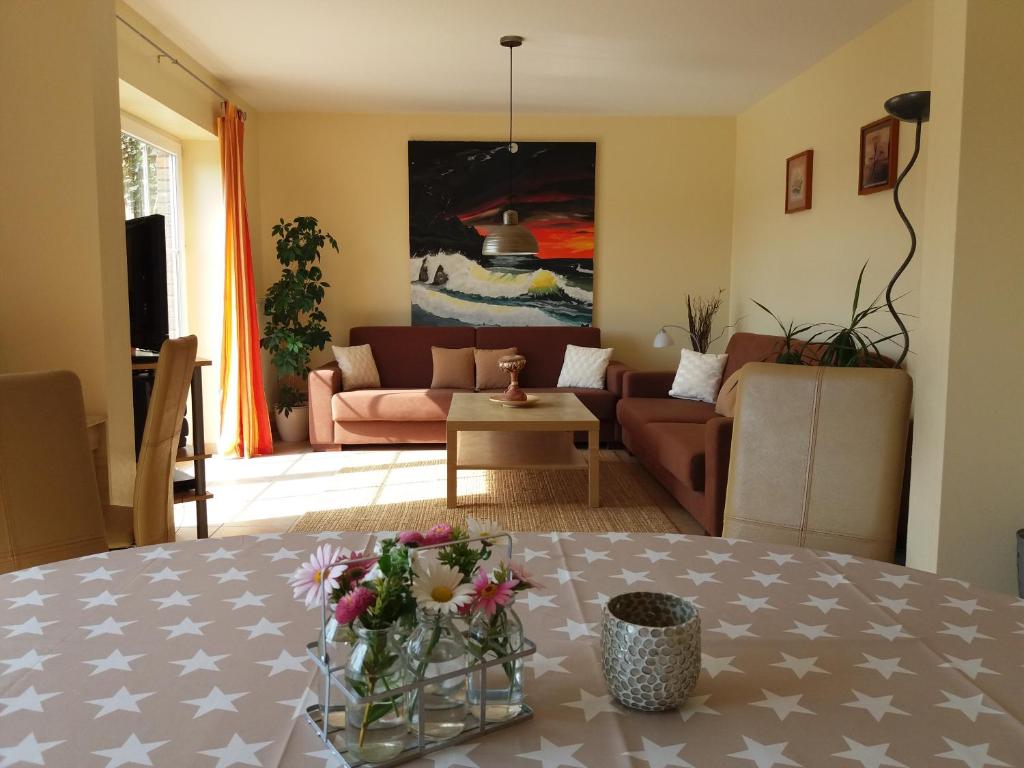 una sala de estar con una mesa con flores. en FeWo am Pohlsee, en Langwedel