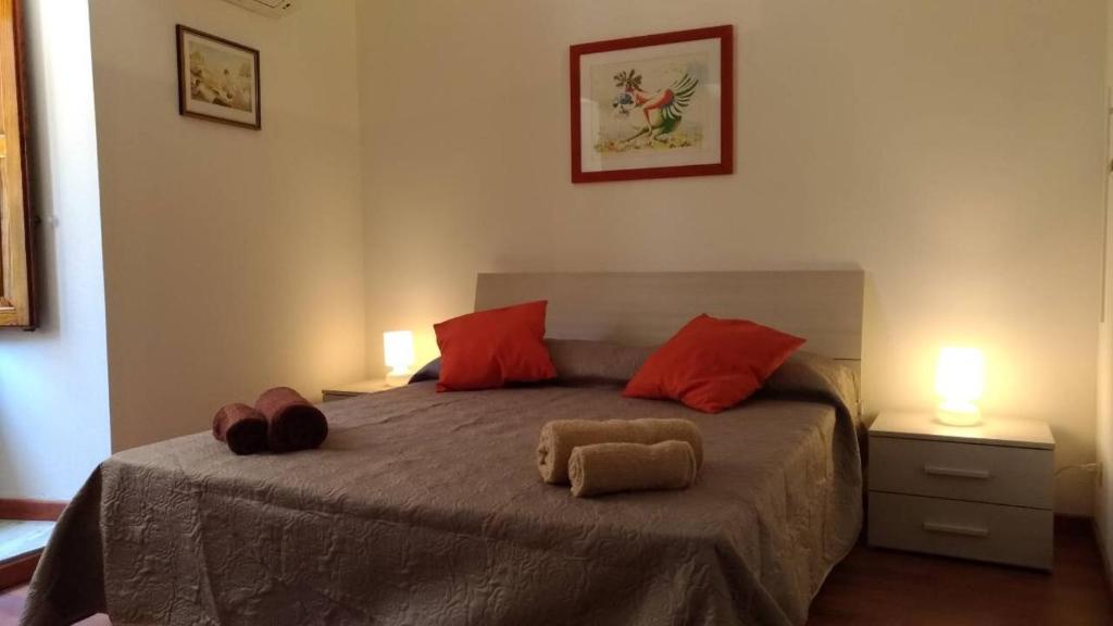 1 dormitorio con 1 cama grande con almohadas rojas en A casa di Lori, en Catania