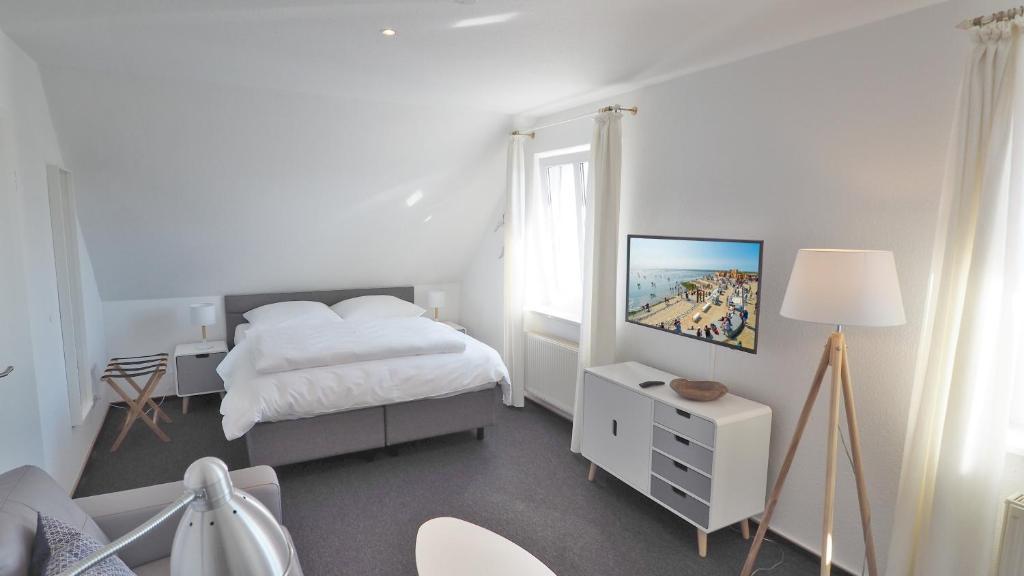 een witte slaapkamer met een bed en een raam bij Westerstrasse Kajüten in Büsum