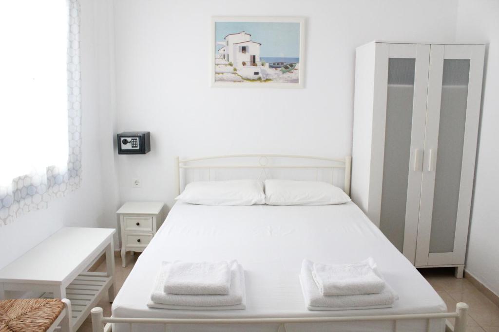 una camera con letto bianco e armadio bianco di Mare Blue Ios a Ios Chora