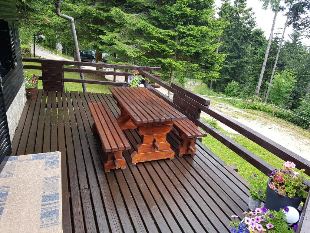 a wooden table and bench on a deck at Rogla - Chalet Mojca Pokrajculja in Zreče