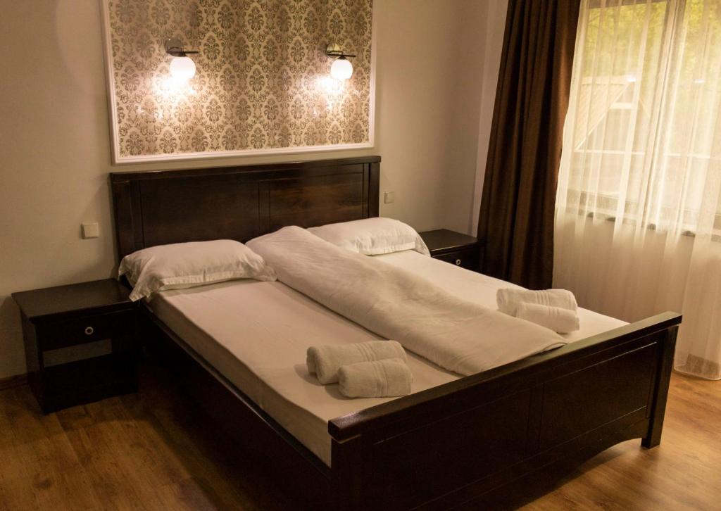 a bed in a bedroom with two towels on it at Casa Valea Cernei in Isverna
