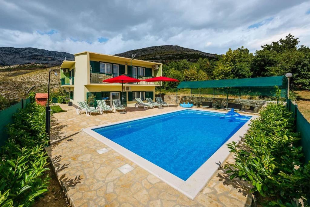 una imagen de una villa con piscina en Holiday Home Cherry Tree, en Žrnovnica
