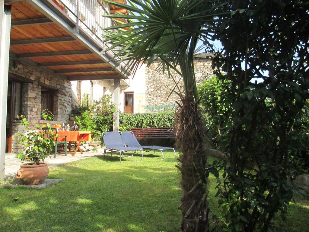 een patio met een stoel en een tafel in de tuin bij Casa Cicala in Trarego