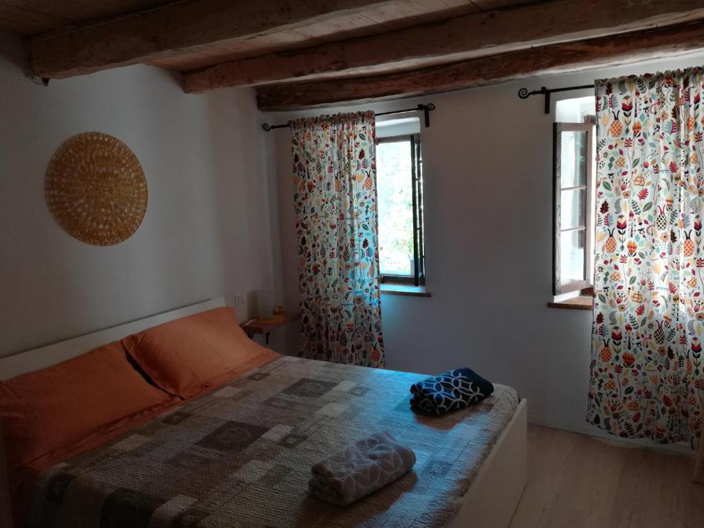 TarzoにあるLa casa dell'Olmoのベッドルーム1室(ベッド1台、窓2つ付)