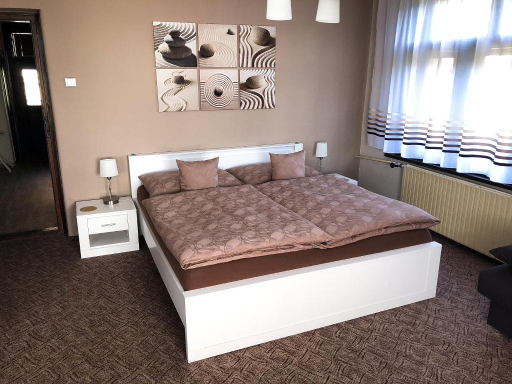 a bedroom with a large white bed in a room at Penzion Z&Z in Tábor