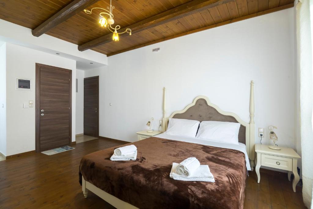 a bedroom with a large bed with towels on it at Zaros in Zaros