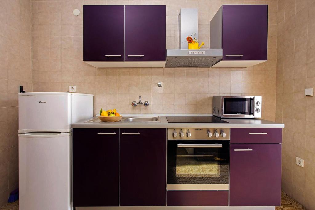 a kitchen with purple cabinets and a white refrigerator at Villa M&M - ZF Hvar in Hvar