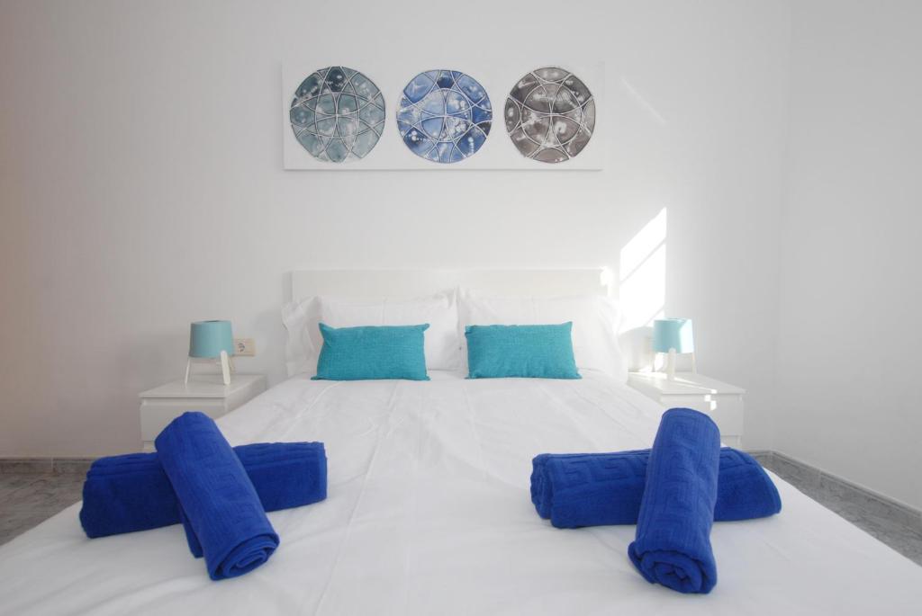 アリエタにあるCalma Suites La Garitaの白いベッドルーム(白いベッドに青い枕付)