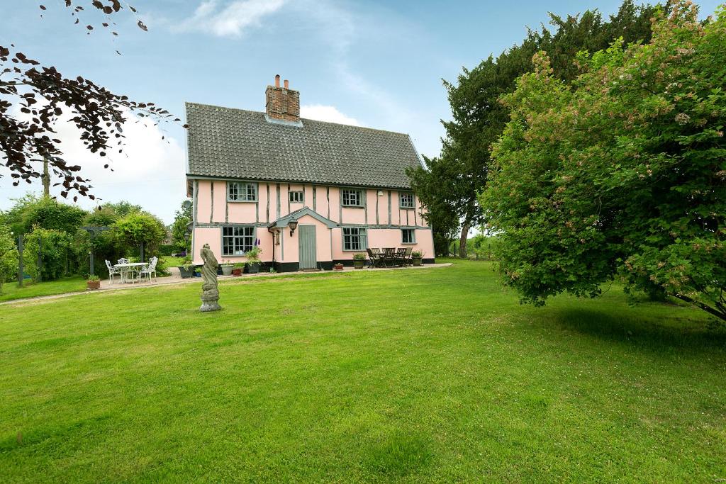 una grande casa in un campo con un prato di Corner Farm a Halesworth