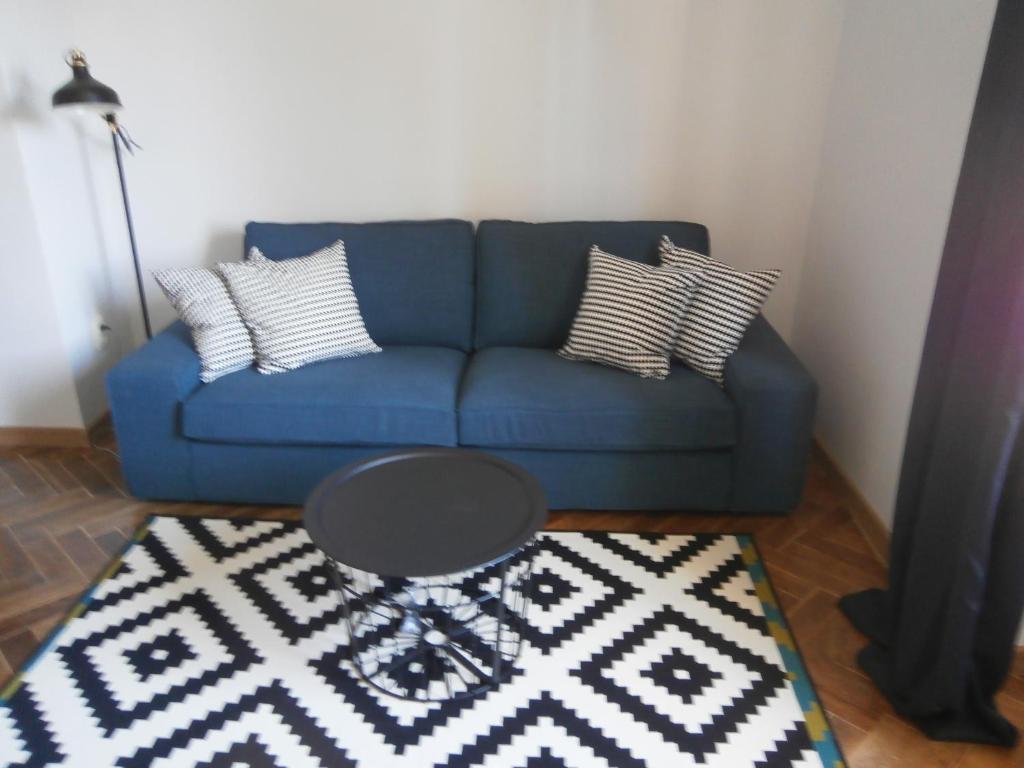 ein blaues Sofa mit Kissen und einen Tisch im Wohnzimmer in der Unterkunft Loft Studio in Giżycko