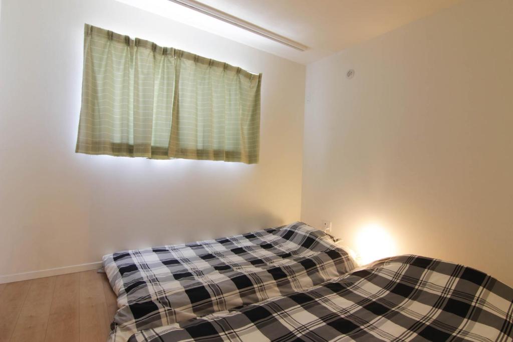 Postel nebo postele na pokoji v ubytování Guesthouse Tokushima