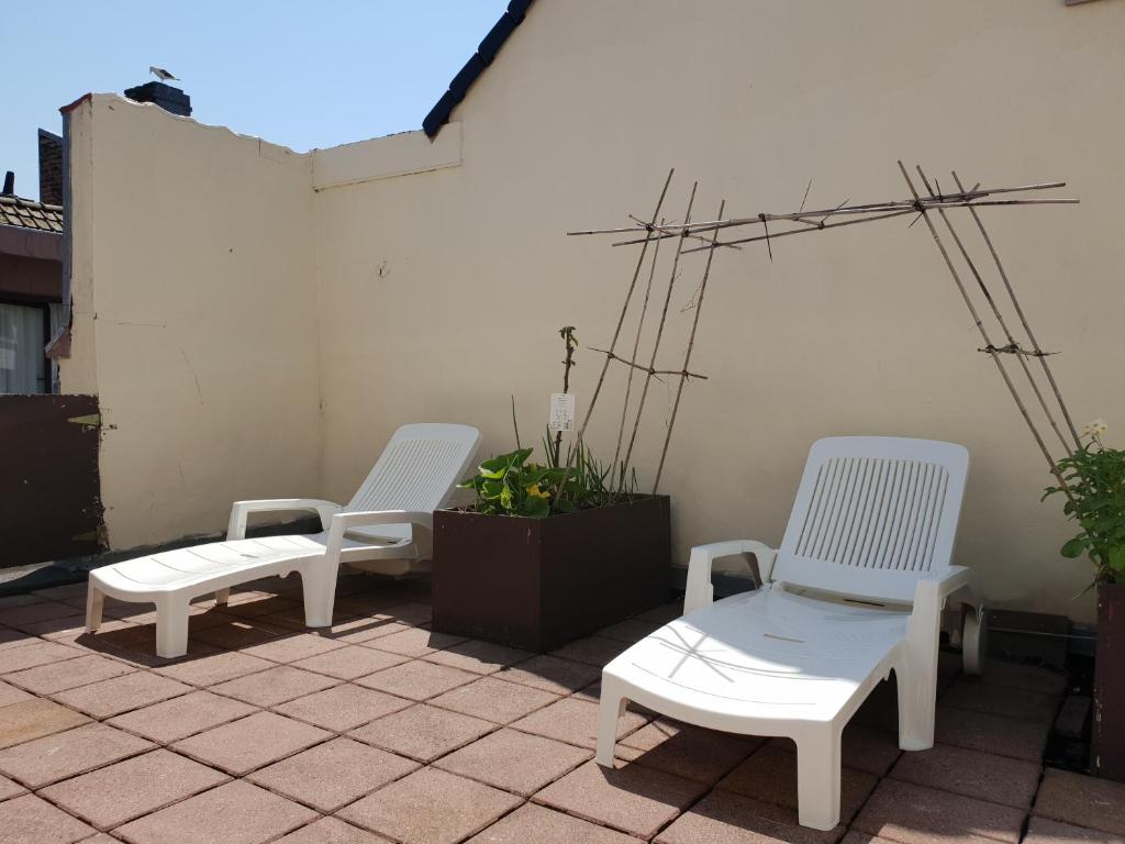 three white chairs sitting on top of a patio at Hotel Albert II Oostende in Ostend