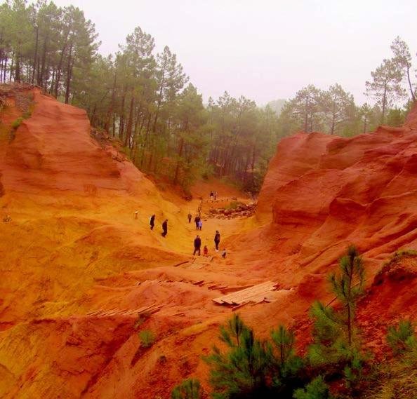 a group of people walking on a dirt hill at La goutte d'or in Roussillon