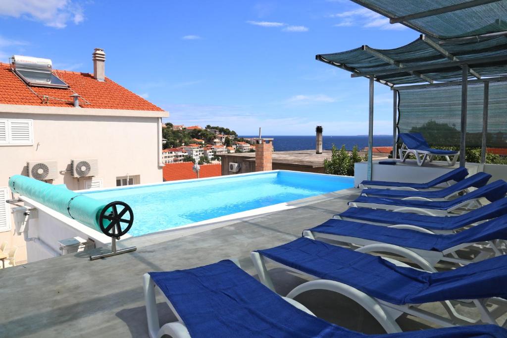 a swimming pool with blue chairs and a swimming pool at Villa Korculaholidays in Zavalatica