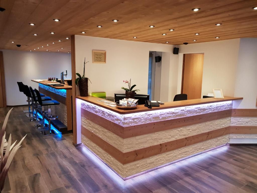 a lobby with a counter with chairs and a reception desk at Hotel Europa in Saas-Fee