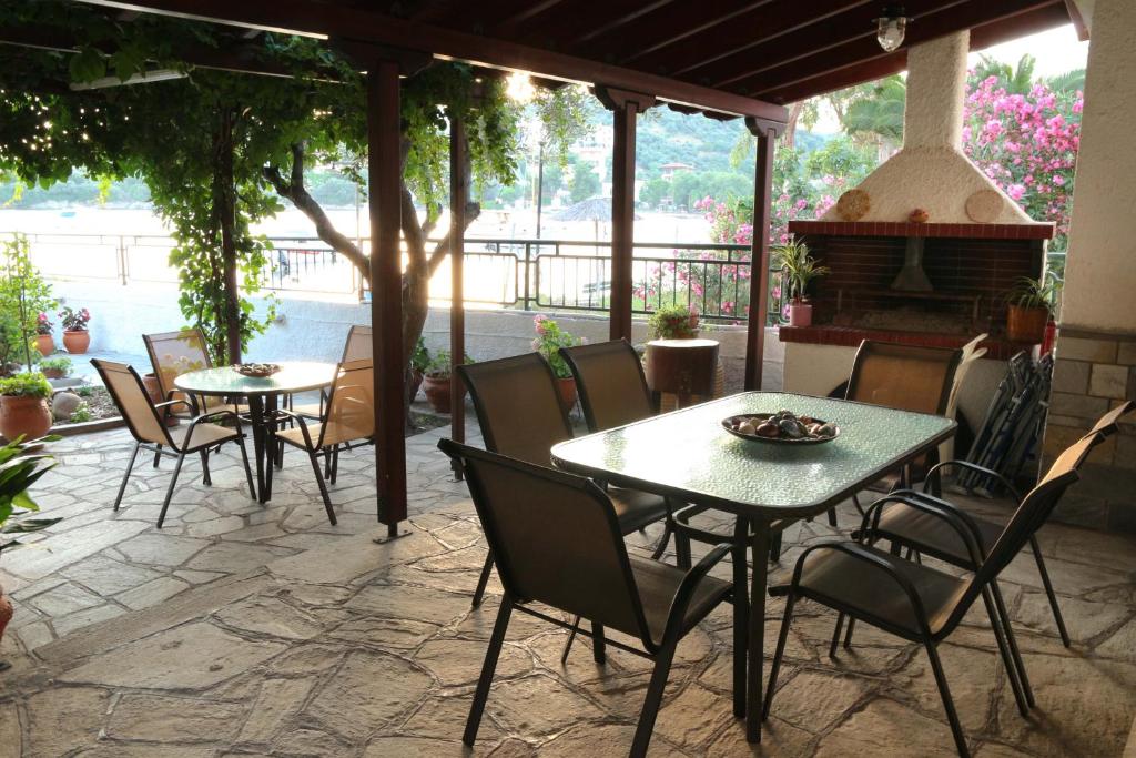 um pátio com mesas e cadeiras e uma lareira em Polianthi Seaside House em Marathos