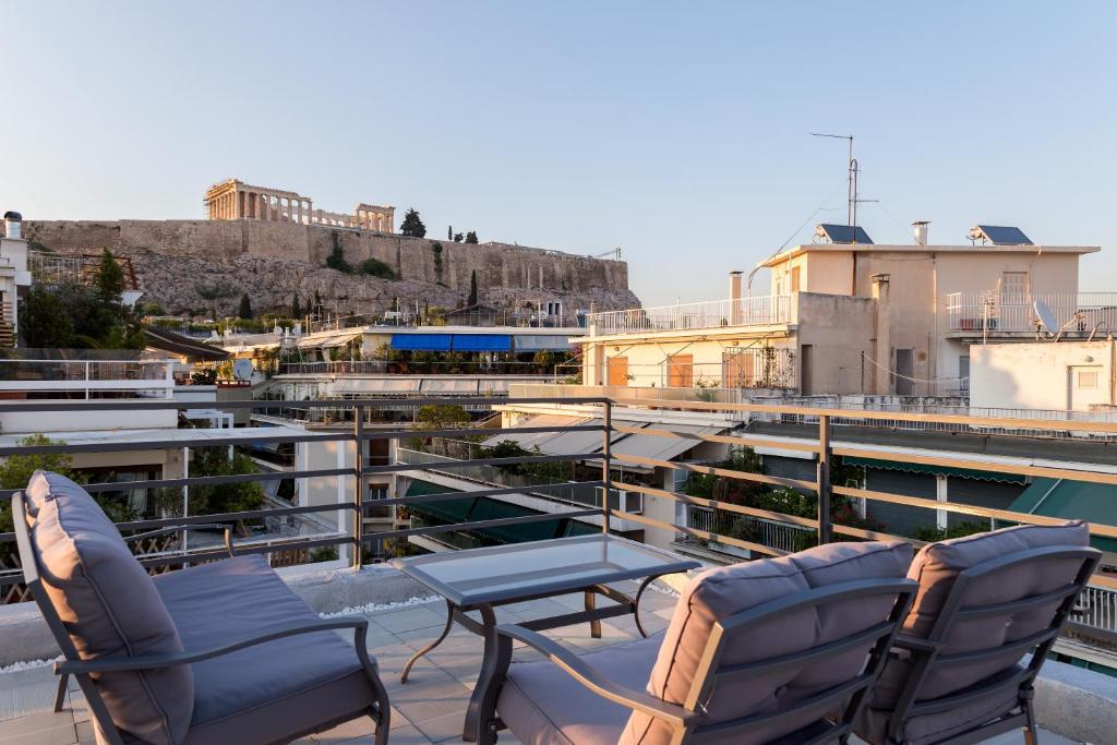 a patio with chairs and a table on a balcony at Acropolis Stylish Suite in Athens