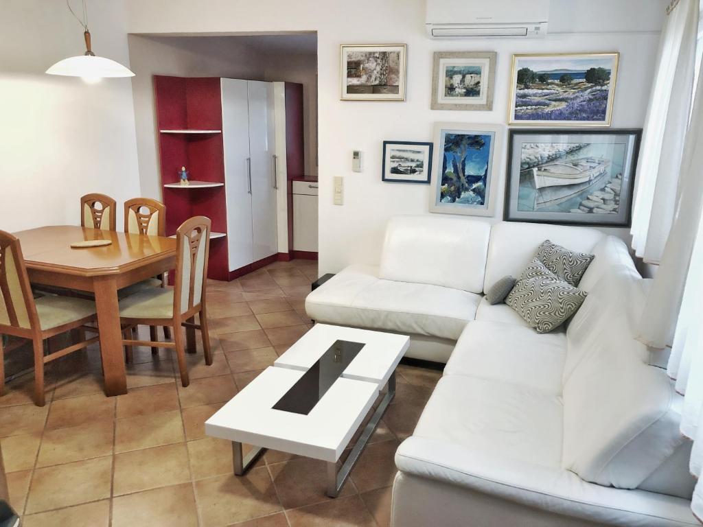 a living room with a white couch and a table at Villa Masha in Omišalj