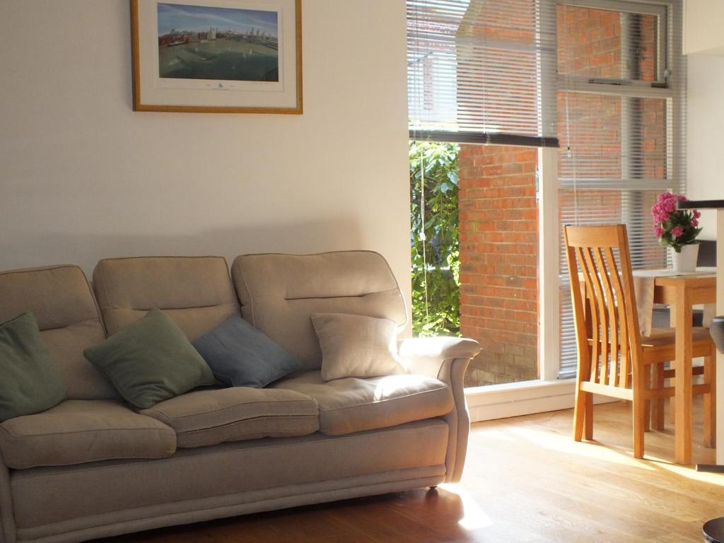 a living room with a couch and a table and a window at Rotherhithe apartment near park and river in London