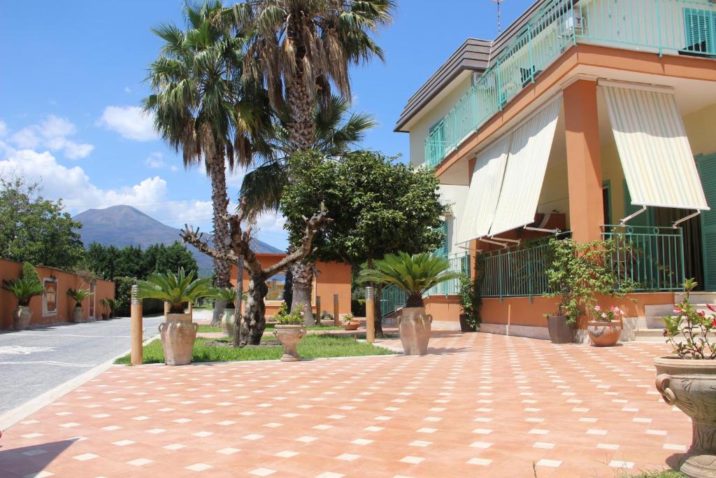 a street in front of a building with palm trees at Villa Julia in Pompei