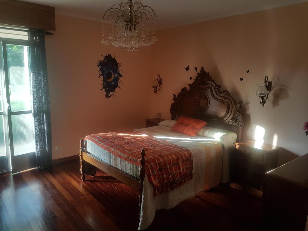 パラーダ・デ・シルにあるCasa Pepeのベッドルーム1室(ベッド1台、シャンデリア付)