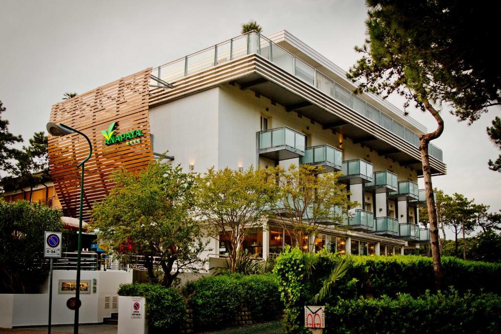 a white building with a balcony on the side of it at Hotel Anapaya in Lignano Sabbiadoro