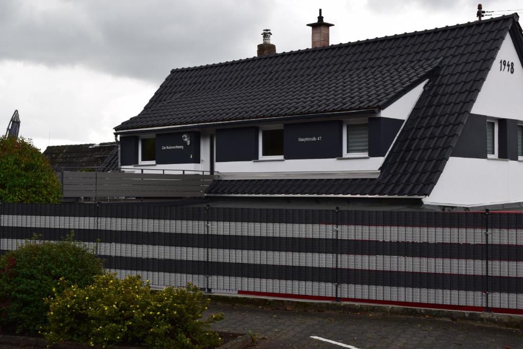 a house with a black roof and a fence at Ferienwohnung Stephanshausen in Stephanshausen