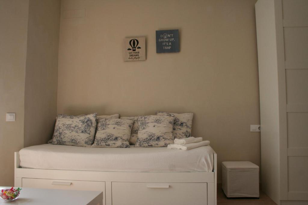 a bedroom with a bed with blue and white pillows at CLB Feria Apartment in Seville