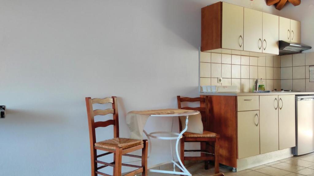 a kitchen with a table and chairs and a counter at Villa Maraki in Agia Paraskevi