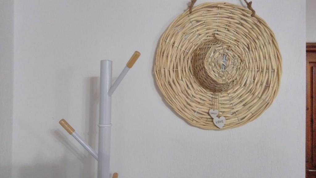 a wicker basket hanging on a wall next to a refrigerator at Villa Maraki in Agia Paraskevi