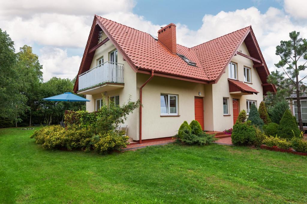 una casa con techo rojo y patio en FOR YOU dom dla 10 osób, en Białogóra