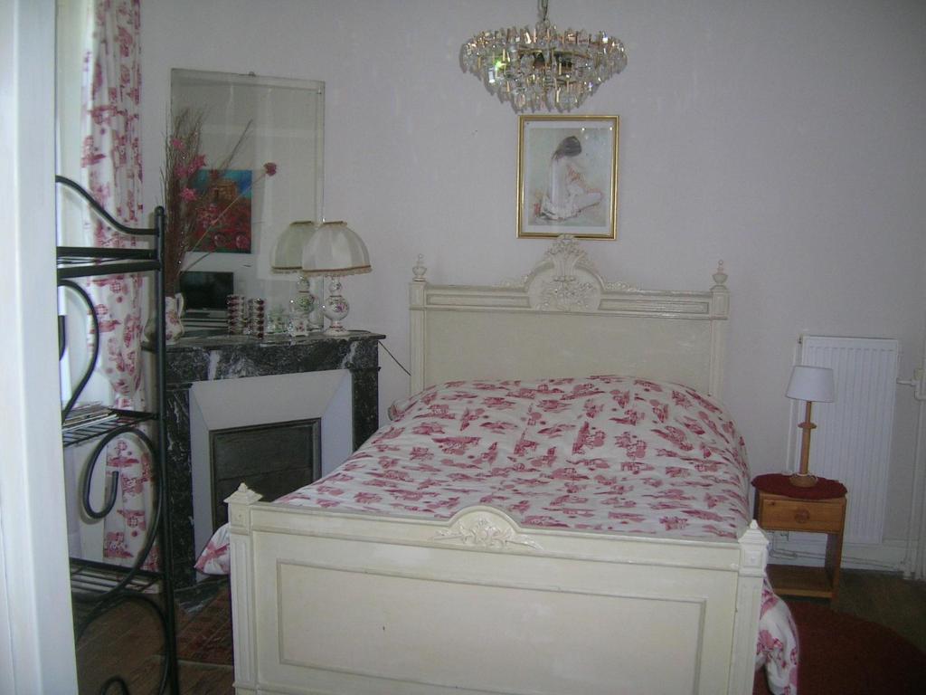 バニョール・ドゥ・ロルヌにあるStudette Villa Odetteのベッドルーム1室(ベッド1台、シャンデリア付)