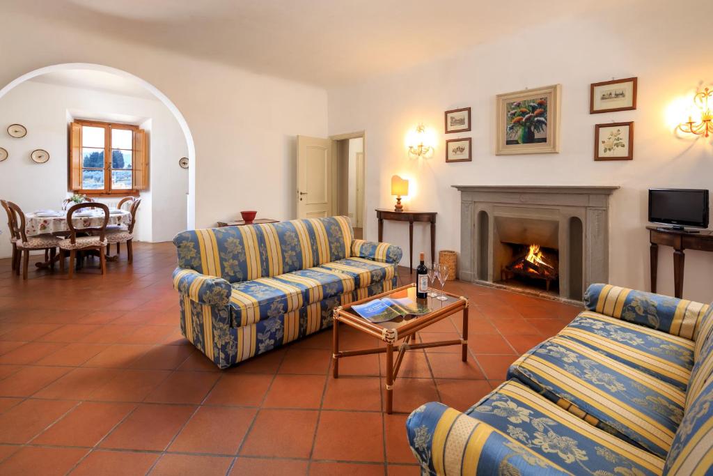 sala de estar con 2 sofás y chimenea en Agriturismo Fattoria di Sommaia, en Calenzano