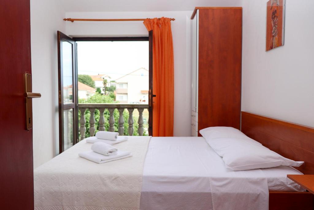 1 dormitorio con 1 cama y ventana con balcón en Apartment Maslina, en Bibinje