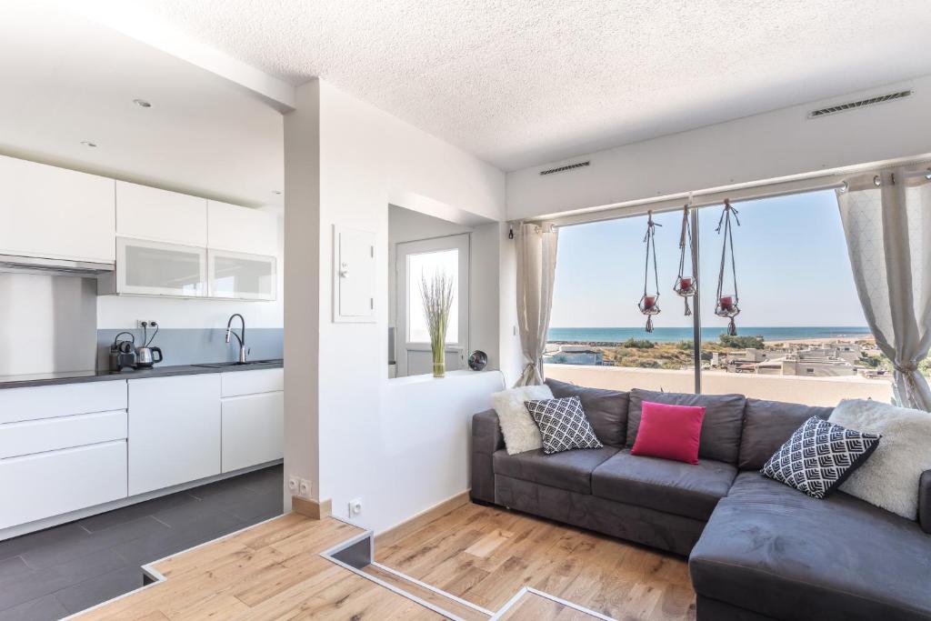 a kitchen and living room with a couch and a view of the ocean at Luxury Penthouse in Naturiste; FKK, Nudist Village in Cap d'Agde