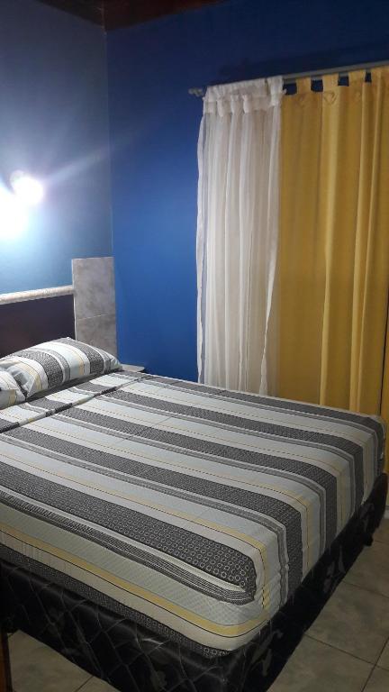 un letto in una camera blu con tenda di Flia Ocampo a Puerto Iguazú