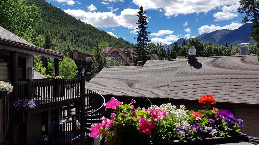 a house with a balcony with flowers on it at Banff International Hostel in Banff