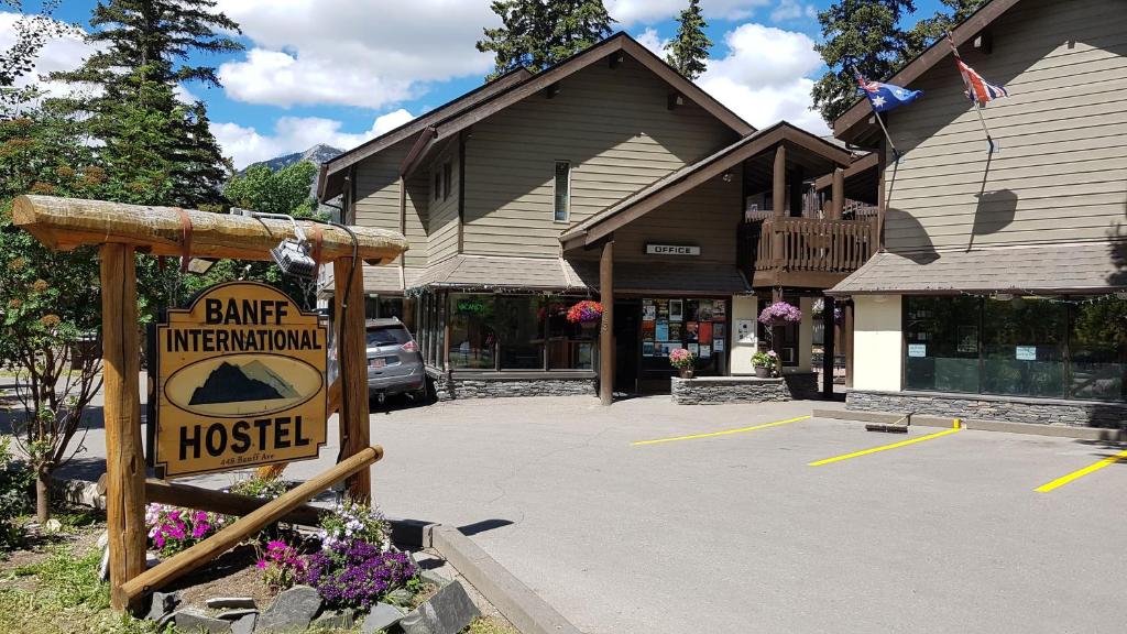 um sinal num parque de estacionamento em frente a um edifício em Banff International Hostel em Banff