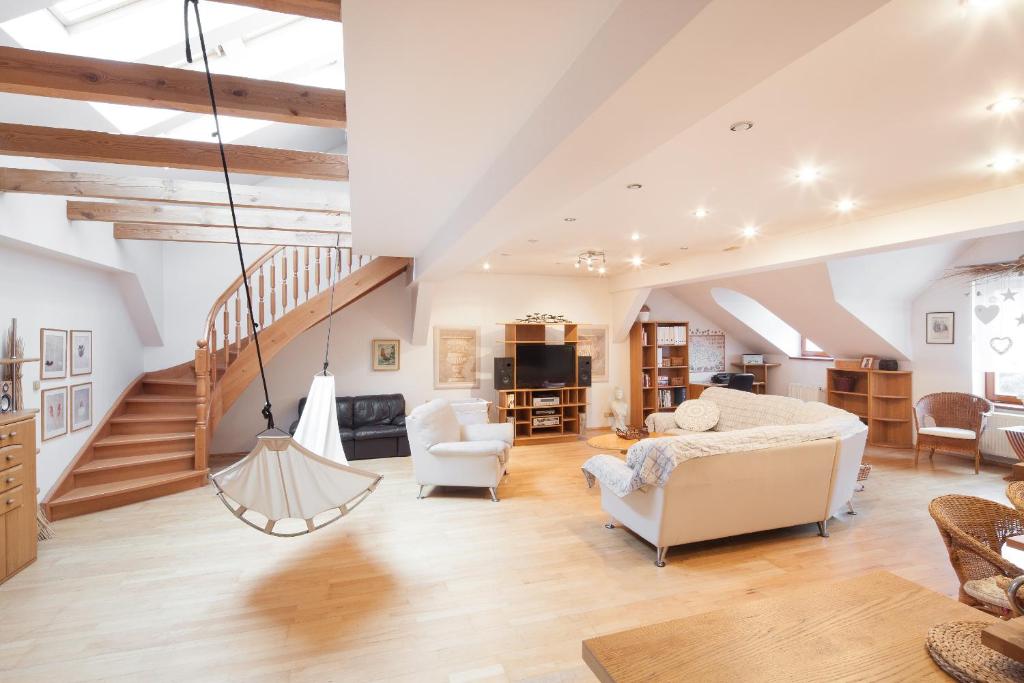 a living room with white furniture and a staircase at Apartment Neratovice in Neratovice