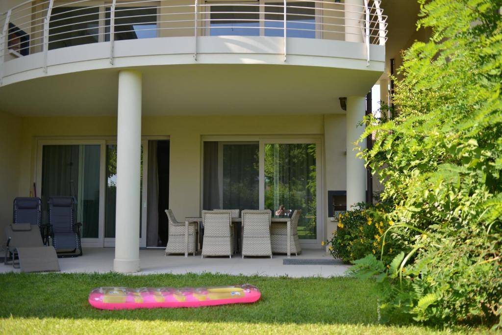 un frisbee rosa sull'erba di fronte a una casa di Sirmione Park View Luxury Apartments a Sirmione