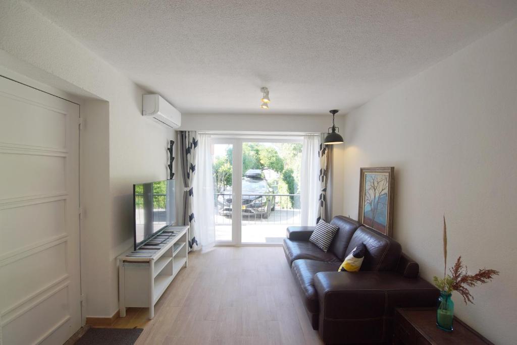 a living room with a couch and a television at Lei Home in Cascais