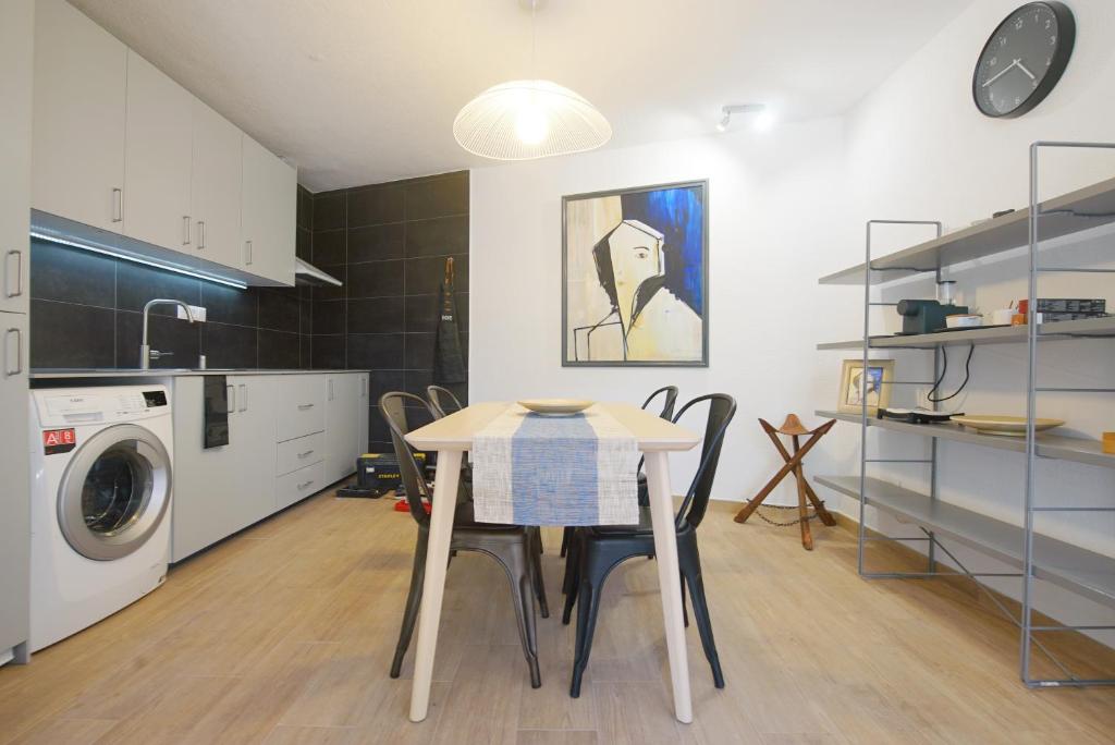 a kitchen with a table and a washing machine at Lei Home in Cascais