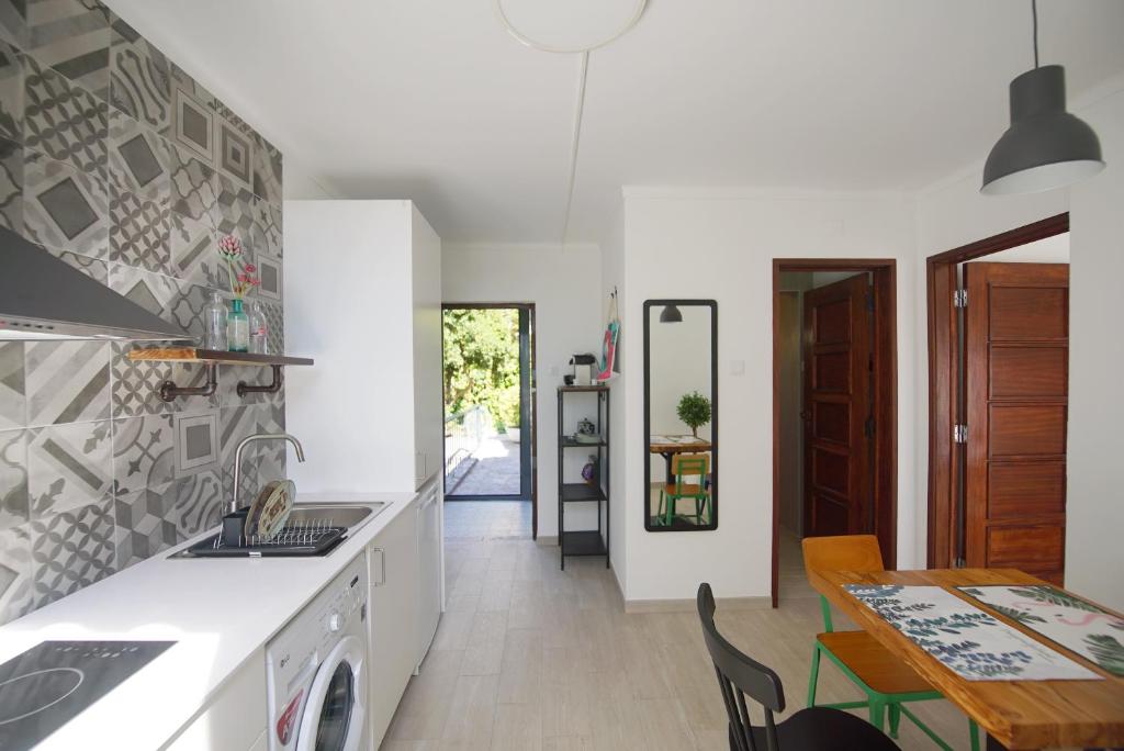 a kitchen with a sink and a table with a dining room at Lei Home in Cascais