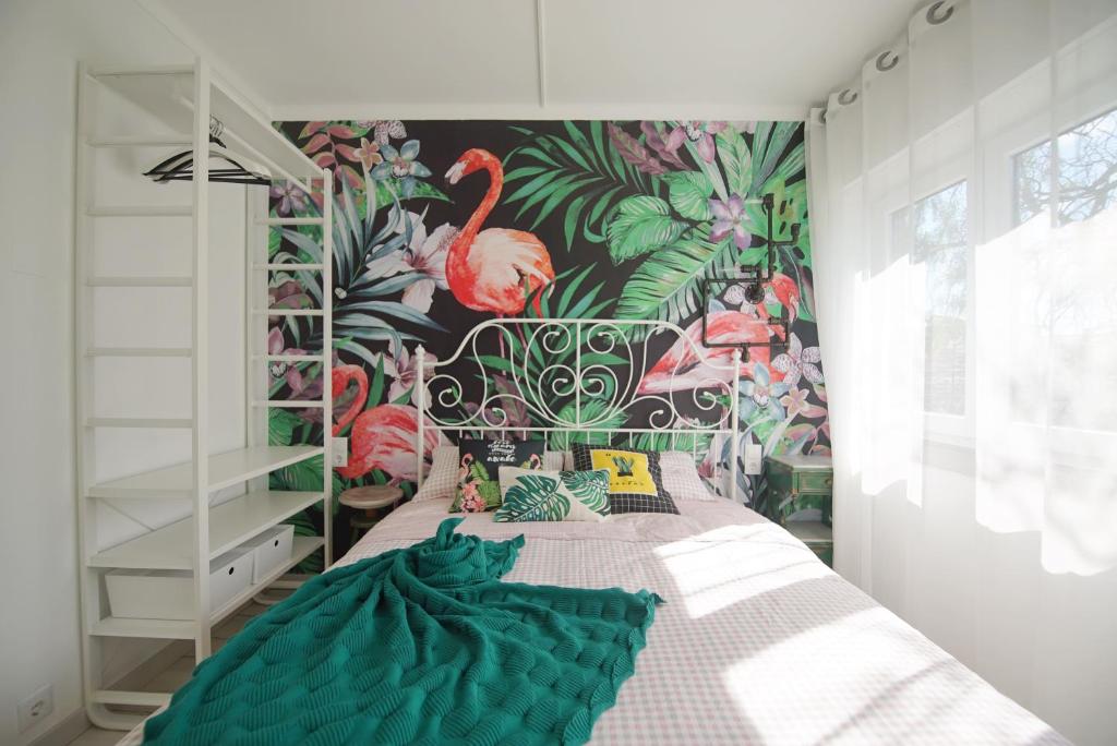 Schlafzimmer mit einem Bett mit Flamingo-Tapete in der Unterkunft Lei Home in Cascais